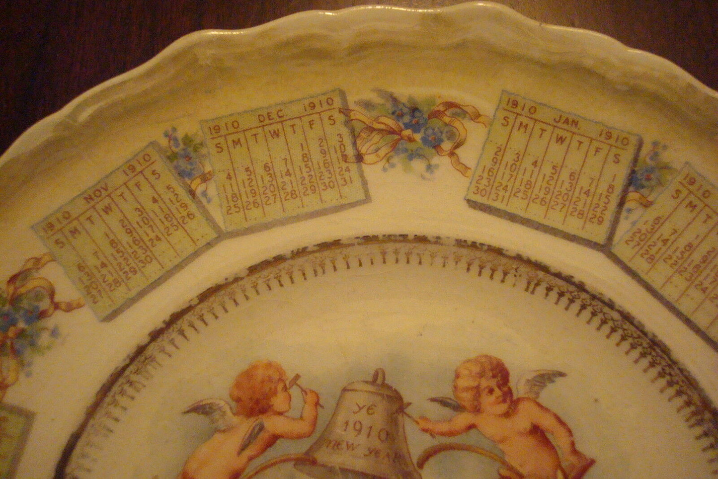 Unmarked 1910 calendar plate angels and bell in center,around 8 1/2" diameter[54