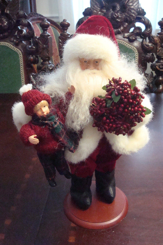 Tina Mitchelll retired Santa, with a large doll and a wreath, ceramic wood base